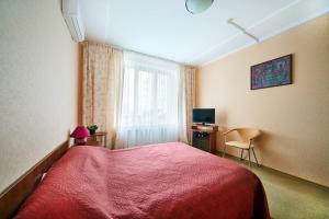 a bedroom with a red bed and a television at Delta Hotel in Sevastopol
