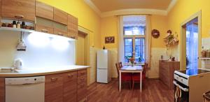 a kitchen with a table and a white refrigerator at Apartmán pod rozhlednou in Roudnice nad Labem