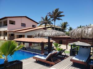 um resort com uma piscina com cadeiras e guarda-sóis em Hotel e Pousada Canoa Quebrada em Canoa Quebrada