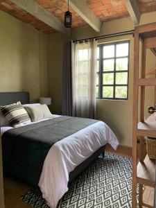 Un dormitorio con una cama grande y una ventana en Bodegas Vaivén Hotel Boutique, en Tequisquiapan