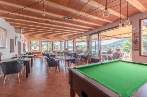 a pool table in a restaurant with tables and chairs at Le Mas de Riri in Celles