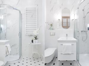 La salle de bains blanche est pourvue de toilettes et d'un lavabo. dans l'établissement Main Square Apartments, à Cracovie