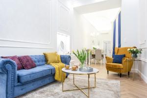 a living room with a blue couch and chairs at Main Square Apartments in Kraków