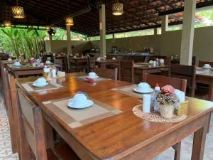 Pousada Do Rio Barreirinhas في باريرينهاس: طاولة خشبية كبيرة في مطعم مع كراسي
