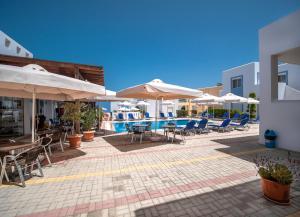 
a patio area with chairs, tables and umbrellas at Gennadi Gardens Apartments & Villas in Gennadi
