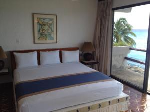 um quarto com uma cama e vista para o oceano em Condumel em Cozumel