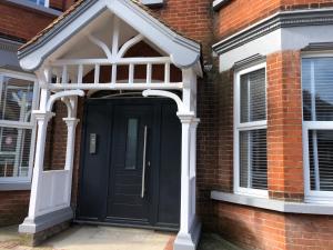 a black front door of a brick house at The Duplex with Air Conditioning & Private Deck Area in Margate