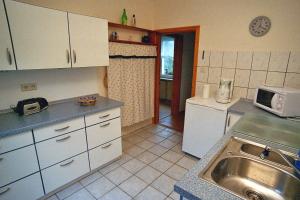 - une cuisine avec des placards blancs et un évier dans l'établissement Ruegen_Fewo 35, à Putbus