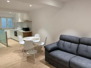 a living room with a couch and a table and chairs at Aldamar apartamentua PARKING INCLUIDO in Getaria