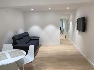 a living room with a black couch and a table at ALDAMAR parking incluido in Getaria