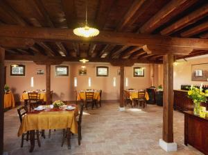 a dining room with tables and chairs and wooden ceilings at Tenuta Le Risare in Campo San Martino +20 photos