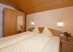 a bedroom with a large white bed with two pillows at Rüf Wohlfühl-Apartments in Au im Bregenzerwald