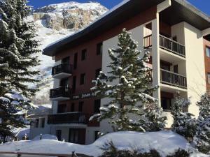 a snow covered christmas tree in front of a hotel at R&eacute;sidence Studio Sakura in Val dʼIs&egrave;re