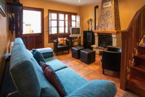 PorrúaにあるEl Llagu Villa Megustaruralのリビングルーム(青いソファ、暖炉付)