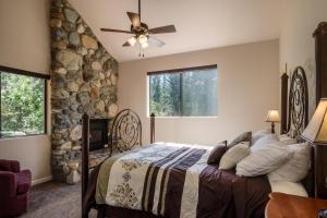 1 dormitorio con cama y pared de piedra en Yosemite Magic "A", en Yosemite West