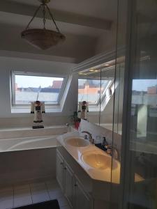 a bathroom with a sink and a tub and a mirror at B&B De Mansarde in Diest