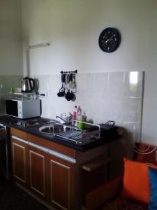 a kitchen with a sink and a clock on the wall at Apartments Laura in Stara Baška