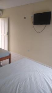 a bedroom with a bed with a tv on the wall at Pousada Potiguara Irapuan in Iranduba +20 photos