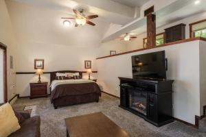 1 dormitorio con 1 cama, chimenea y TV en Yosemite Magic Studio "B", en Yosemite West