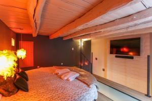 a bedroom with a bed with a tv on the wall at L'Escale Dinard in Tréméreuc