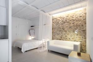 a white bedroom with a bed and a couch at Estudio Casco Antiguo Inmomart in Peniscola