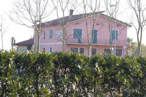 ミーラにあるCedro Venice Apartmentの木の垣根の後ろにあるピンク色の家