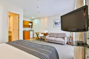 um quarto de hotel com uma cama e uma televisão de ecrã plano em eSuites Sorocaba by Atlantica em Sorocaba