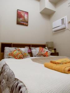 a bedroom with two beds and a picture on the wall at YokosoCEBU & Private Parking in Cebu City
