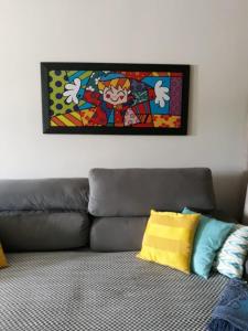 a painting hanging on a wall above a couch at Apartamento Capitolio in Capitólio