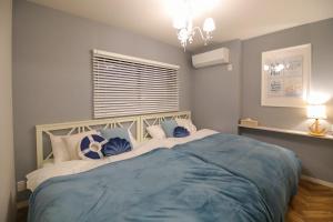 a bedroom with a large bed with blue sheets at Costiera Osaka Bay in Osaka