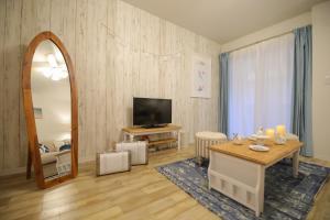 ein Wohnzimmer mit einem Tisch und einem Spiegel in der Unterkunft Costiera Osaka Bay in Osaka