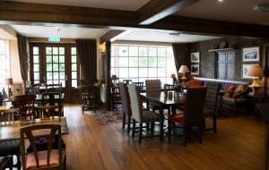 a restaurant with wooden floors and tables and chairs at Saracens Head in Beddgelert
