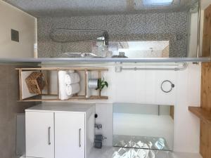 uma pequena cozinha com armários brancos e um lavatório em Finca La Paz em San Miguel de Abona