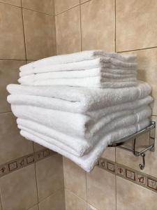 ein Stapel weißer Handtücher auf einem Handtuchhalter in einem Badezimmer in der Unterkunft Cálido Destino in Ushuaia