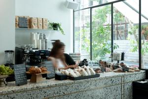 a woman standing in front of a bakery counter with pastries at ISLA Tel Aviv in Tel Aviv