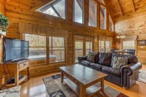 a living room with a couch and a tv in a cabin at Affair of the Heart in Pigeon Forge