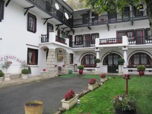 a large white building with windows and a courtyard at Le Chalet Basque in Capvern