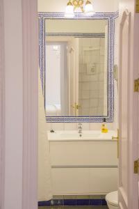 een badkamer met een wastafel en een spiegel bij Apartamento Trajano in Sevilla