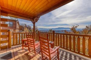 a deck with two chairs and a table on it at Hillbilly Highrise in Pigeon Forge