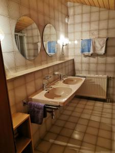 La salle de bains est pourvue de 2 lavabos et d'un miroir. dans l'établissement Ferienwohnung Seidl Top 3, à Rauris