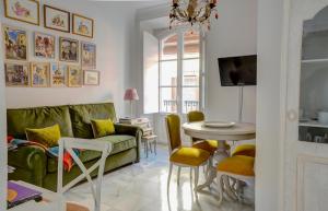 sala de estar con sofá verde y mesa en Apartamento Trajano, en Sevilla