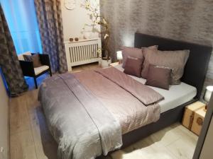 een slaapkamer met een groot bed en een stoel bij Apartament -Sweet Home in Lubin