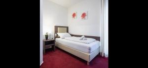 1 dormitorio con cama blanca y alfombra roja en Hotel Restaurant Jaegerhof, en Kerpen