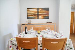 uma mesa de jantar com 2 cadeiras e uma garrafa de vinho em APARTAMENTO AMPLIO. VISTAS A LA PLAYA em Puçol