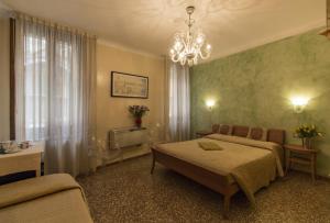 a bedroom with two beds and a couch and a chandelier at Taverna San Lio in Venice