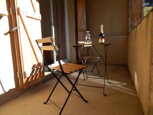 una sedia e un tavolo con una bottiglia di vino di Chevêche a Germ