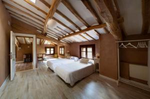 a large bedroom with a large white bed and wooden ceilings at CASA DEL AGUA - La Rioja in Santa Coloma