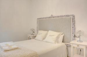 1 dormitorio con 1 cama blanca y 2 mesas en Apartamento Trajano, en Sevilla