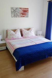 a bedroom with a bed with a blue comforter at Ferienwohnung Millonigg in Vorderberg