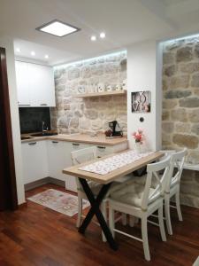 a kitchen with a wooden table and chairs at V&M Luxury Studio in Pag